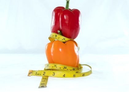 a red pepper sitting on top of a measuring tape